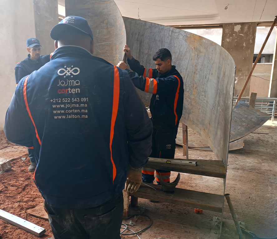 Équipe réalisant le prémontage d’un escalier Maroc en acier sur mesure en atelier
