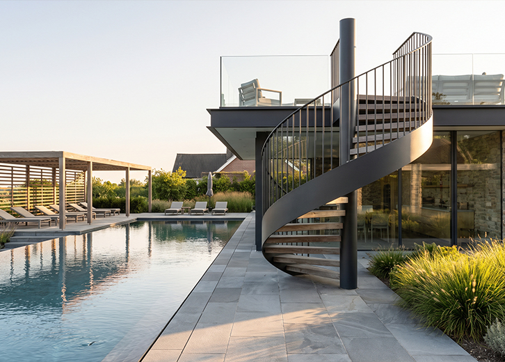 Escalier sur mesure Maroc en colimaçon métallique extérieur près d’une piscine et d’une terrasse