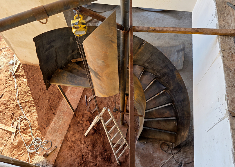 Fabrication escalier sur mesure avec assemblage mécanique et positionnement d’une structure métallique courbe sur chantier